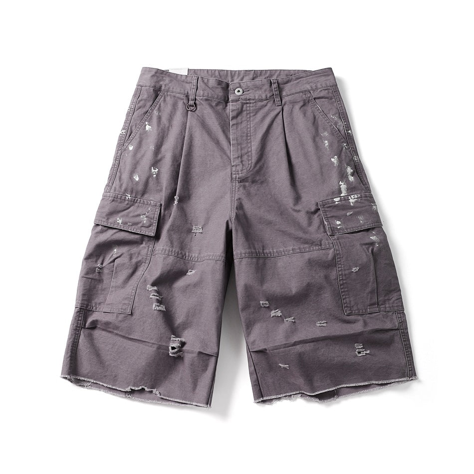 Purple cargo shorts, front flat lay, with distressed holes, paint splatters, flap pockets and a raw frayed hem