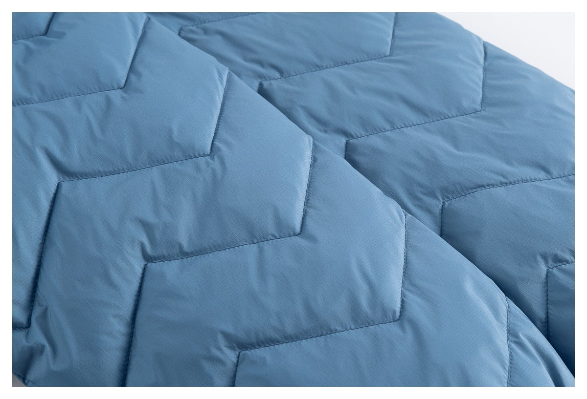 Close-up of blue jacket fabric with geometric quilted stitching.