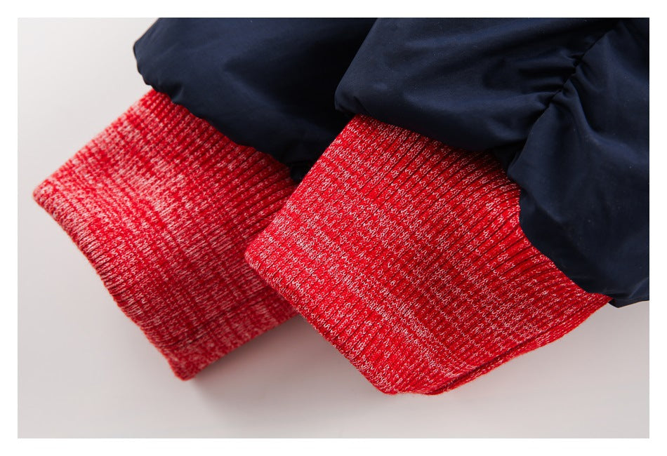 Close-up of bright red marled ribbed cuffs on a navy jacket.