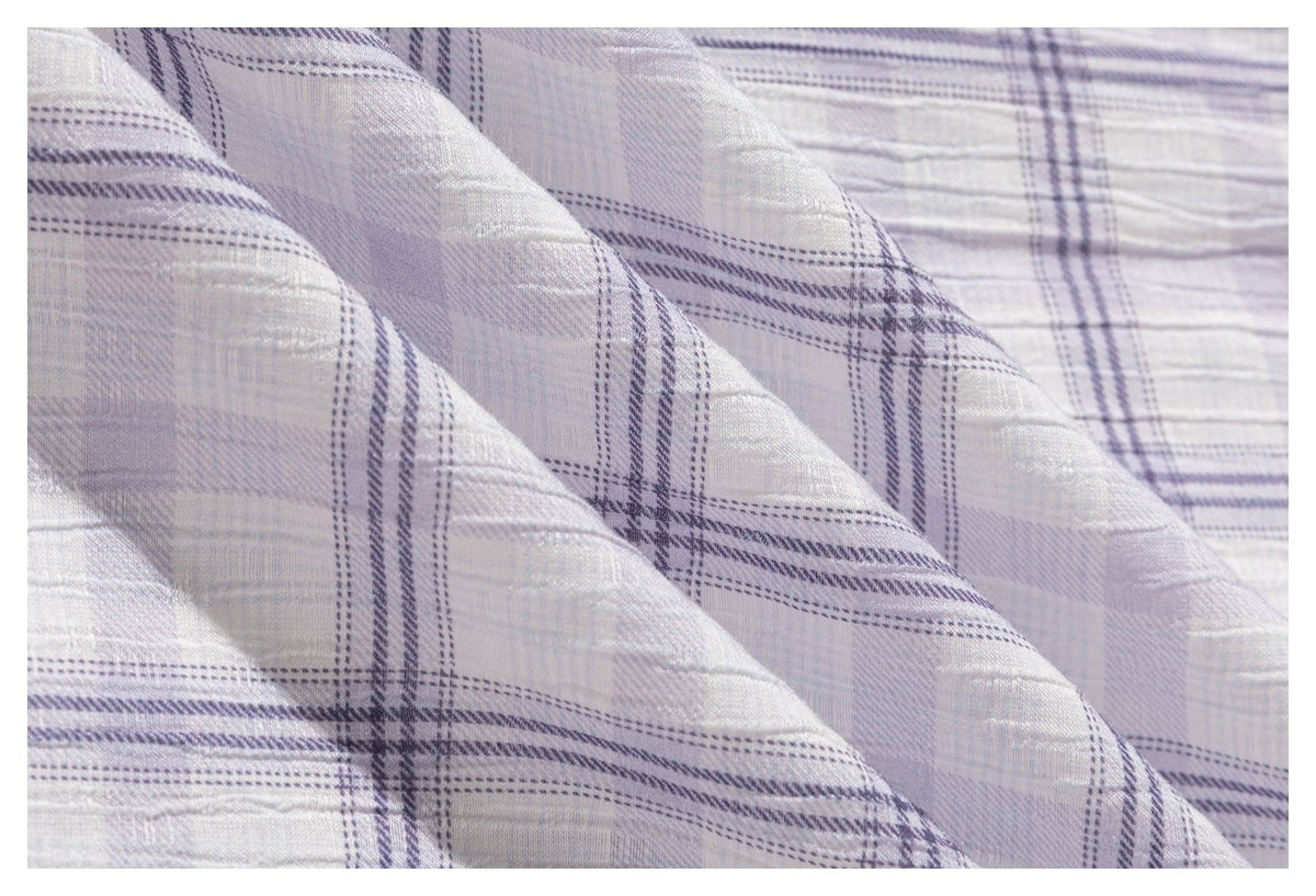 Macro view of the light gray-lavender plaid fabric, showing its woven texture and intersecting lines.