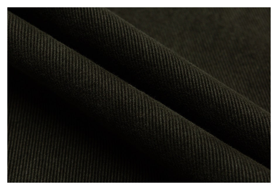 Close-up of dark olive-black fabric with a fine diagonal ribbed texture and soft folds.