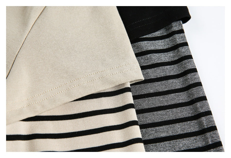 Close-up of layered short sleeves over striped long sleeves in beige and gray with black stripes.