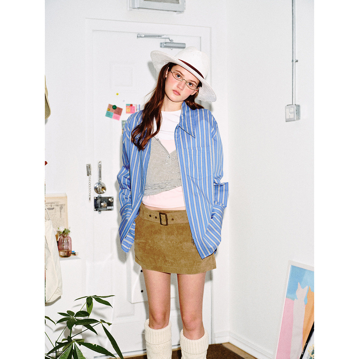 Closer front view of a model wearing an oversized blue striped shirt with a chest pocket.