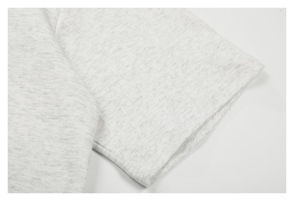 Close-up of the short sleeve and stitched hem on a light gray marled T-shirt.