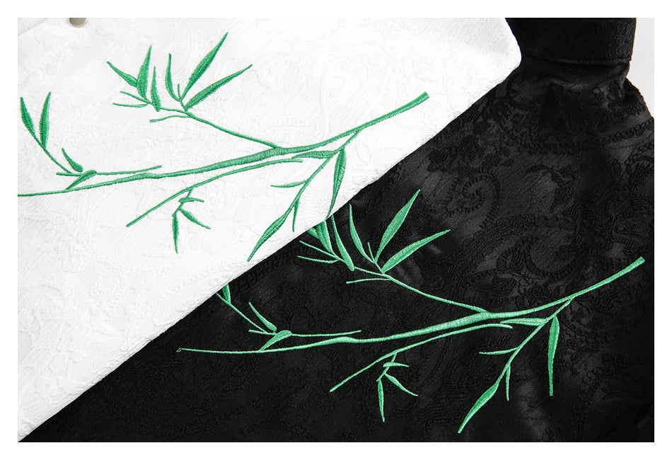 Close-up of green bamboo embroidery on the textured white and black shirts.