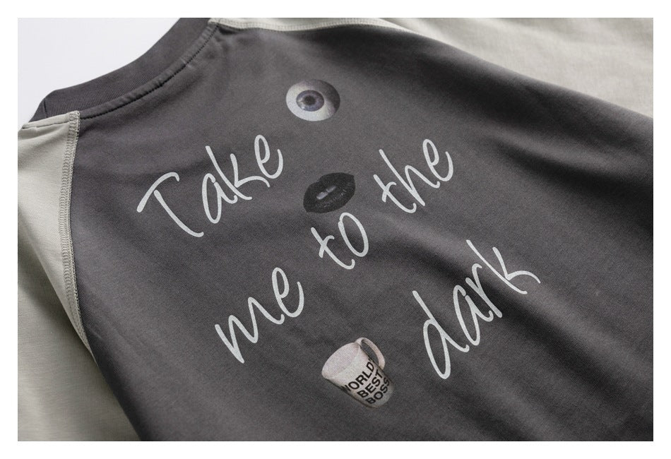 Close-up of a charcoal top's back graphic reading “Take me to the dark,” with small illustrations.