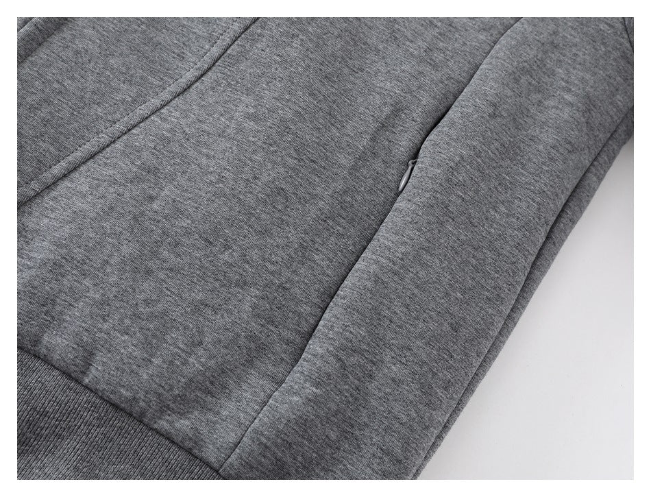 Close-up of a heather-gray jacket pocket with a small zipper and ribbed hem.