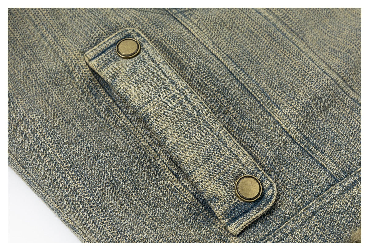 Close-up of a blue-gray jacket placket with two brass-tone snap buttons and visible textured stitching.