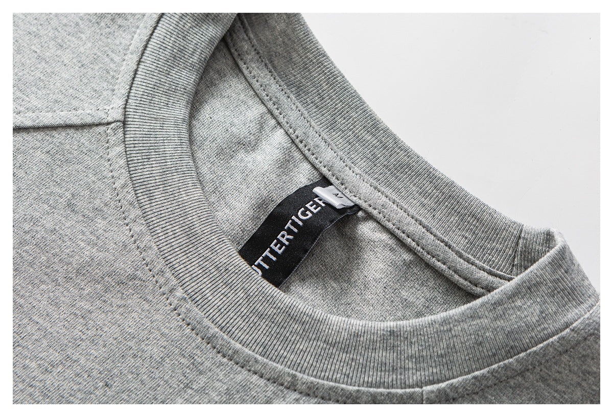 Close-up of a heather gray crew-neck shirt collar with a black sewn-in label.