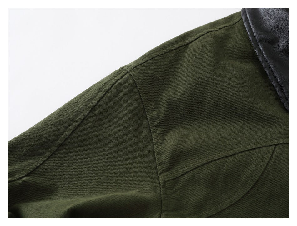 Close-up of the olive jacket shoulder seam and curved yoke stitching, with part of its black collar visible.