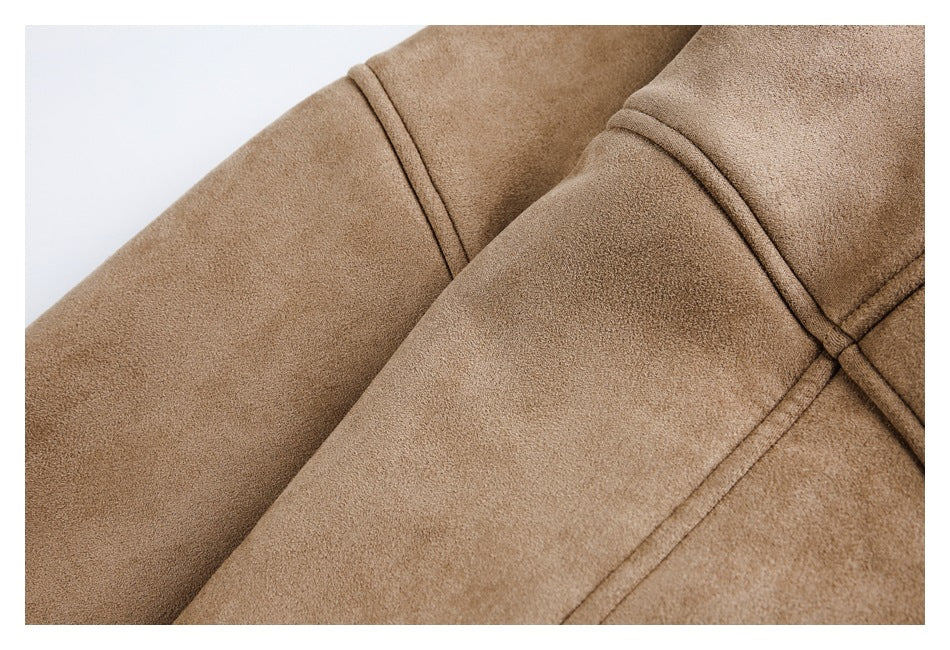 Close-up of a tan coat showing curved stitched seams and overlapping fabric panels.