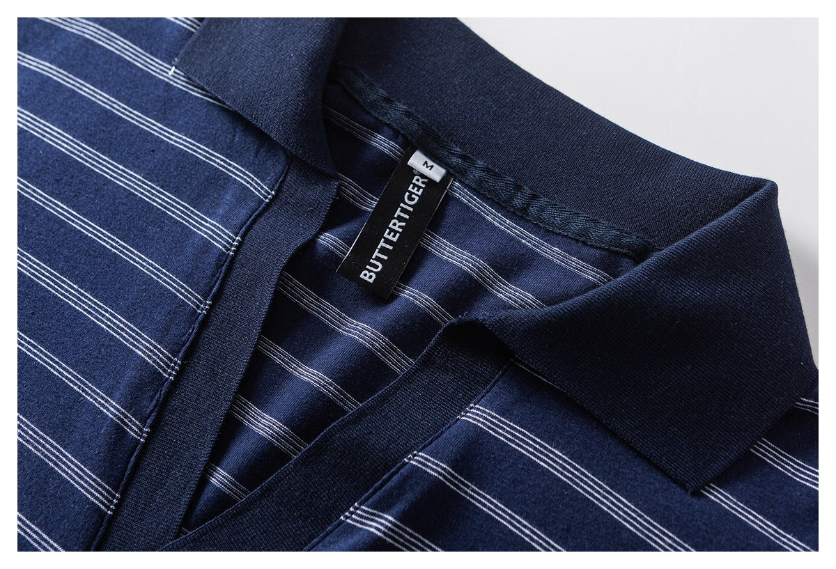 Close-up of the navy polo collar and placket with thin white stripes and a sewn-in neck label.