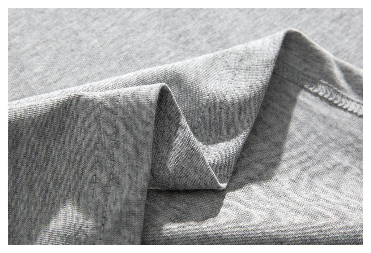 Close-up of a light gray shirt seam, showing the stitching and overlocked inner edge.