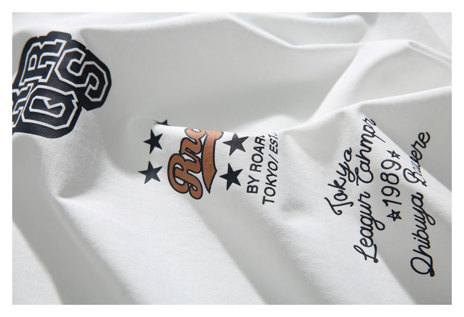 Close-up of white fabric with enlarged black, white, and brown lettering, stars, and script.