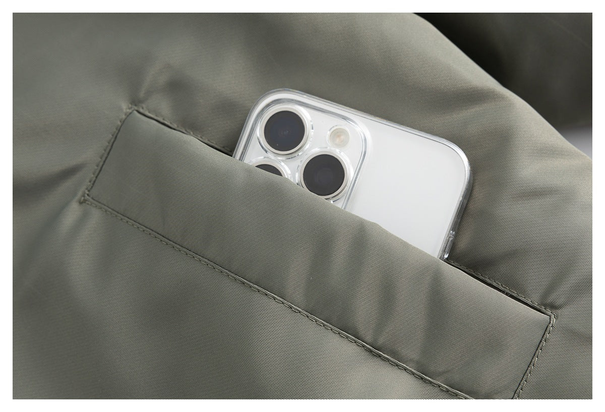 Close-up of a phone tucked into a stitched pocket on the olive-gray jacket.