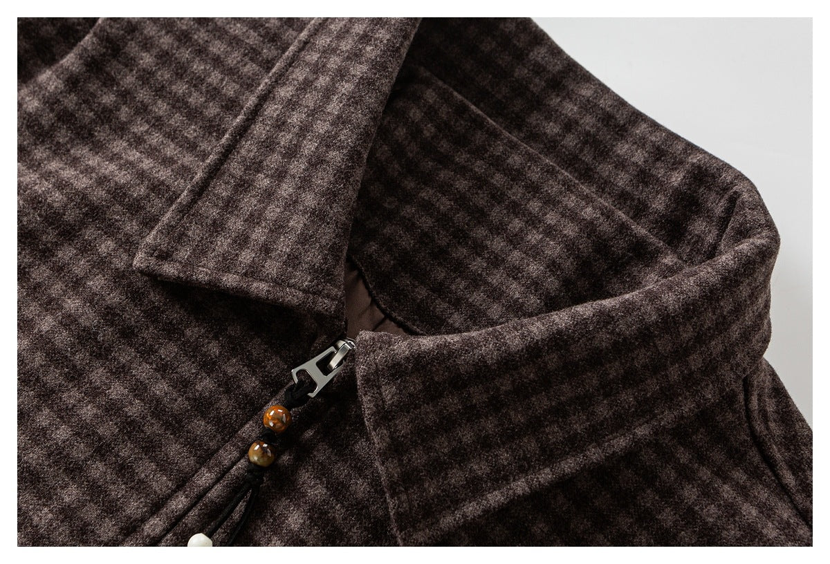 Close-up of a dark brown mottled coat collar and zipper with decorative bead pull.