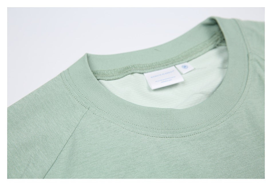 Close-up of a mint green shirt's ribbed crew neckline and inner neck label.