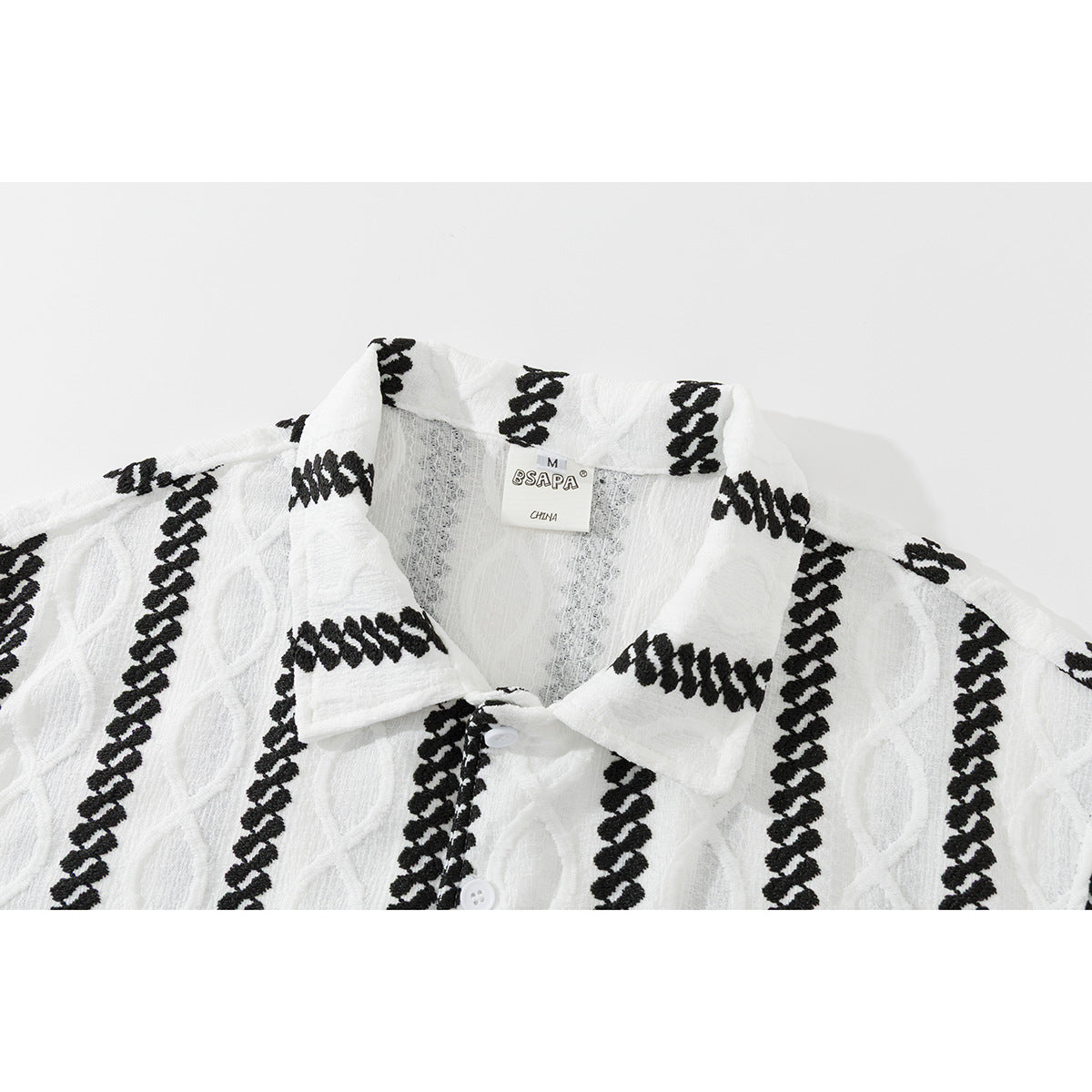 Close-up of a white collared shirt with black vertical braided stripes and a visible neck label.