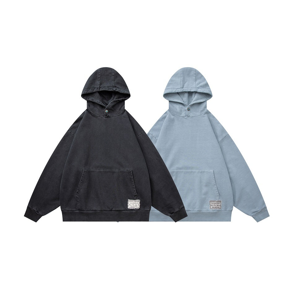Two hooded pullovers shown from the front in charcoal and pale blue, each with a kangaroo pocket and small hem label.