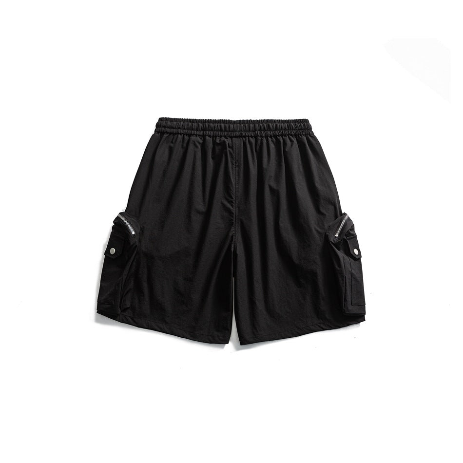 Front view of black shorts with an elastic waistband, side cargo pockets, flap buttons, and zip details.