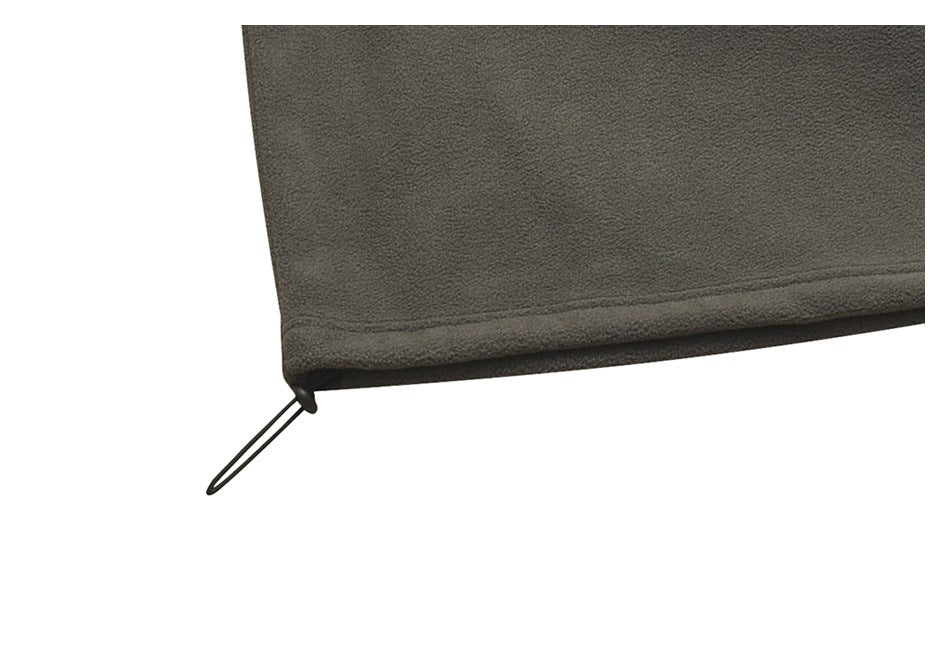 Close-up of a dark charcoal garment hem with a small loop at the corner.