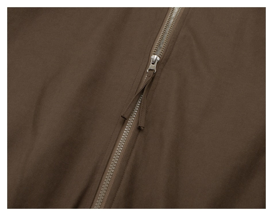 Close-up of the brown jacket's front zipper and metal pull.