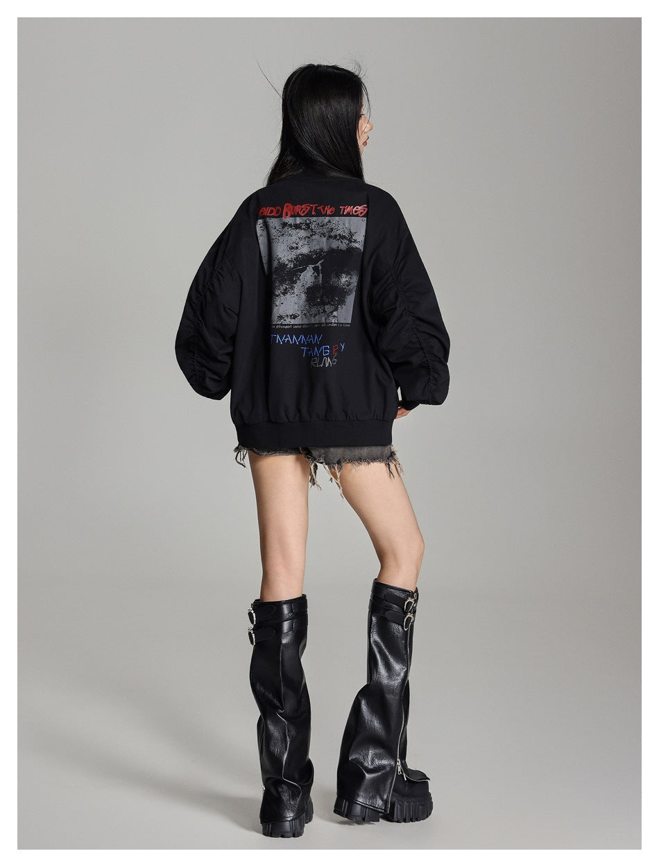 Back view of a person wearing a black bomber jacket with a large graphic print and lettering.