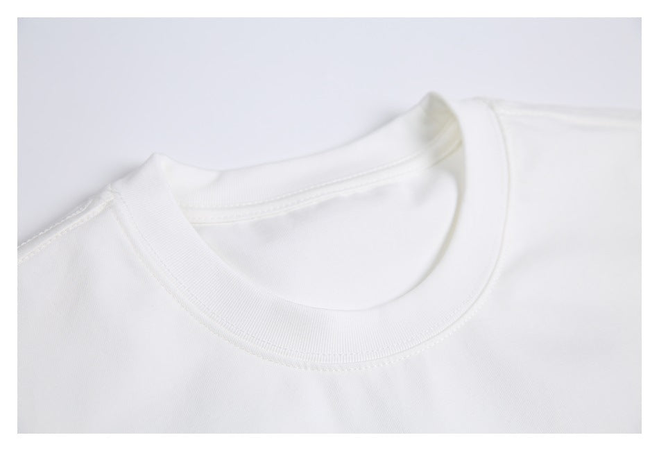 Close-up of the white T-shirt's ribbed crew neckline and shoulder stitching.