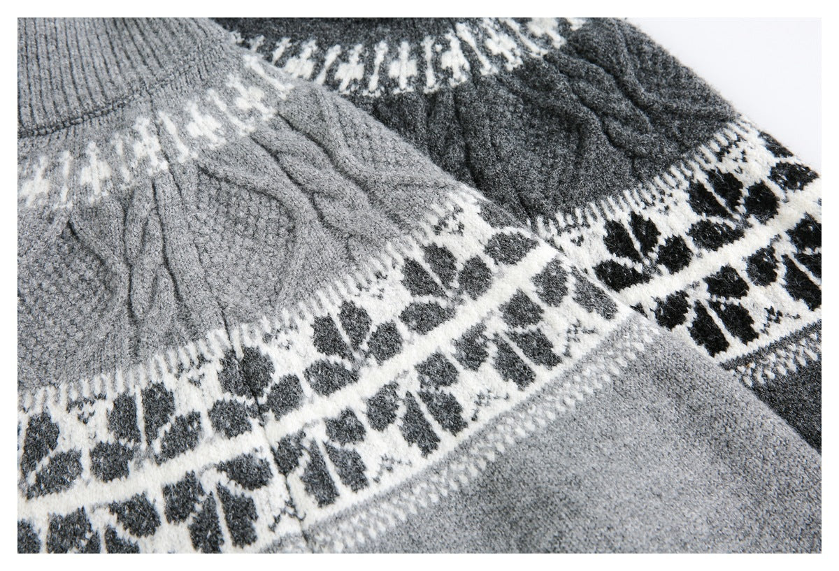 Close-up of gray sweater knit with textured cables and broad white bands of dark geometric motifs.