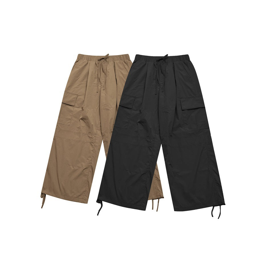 Two pairs of wide-leg cargo trousers shown from the front in tan and black, with drawstring waists and adjustable hems.