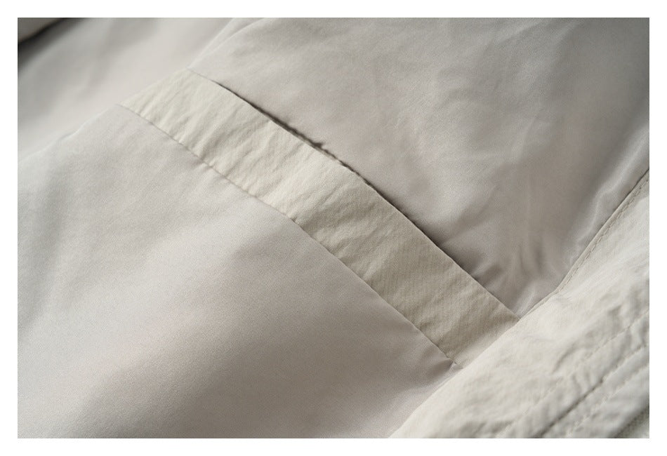 Close-up of the light beige jacket's interior seam and smooth inner panel.