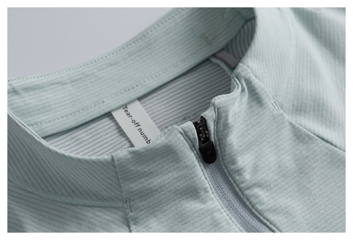 Close-up of the top's pale gray-green stand collar, striped inner neck, and black zipper.