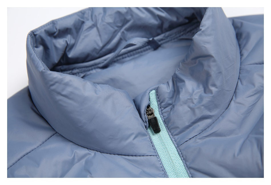 Close-up of the jacket's raised collar and pale aqua front zipper on slate-blue fabric.