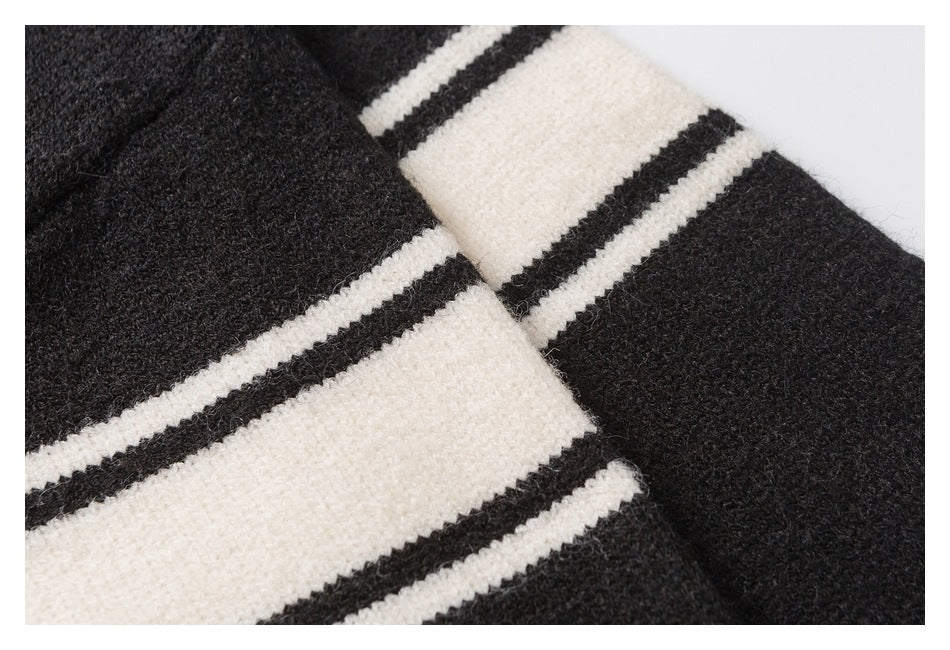 Close-up of black fuzzy knit with broad ivory bands and narrow black stripes.