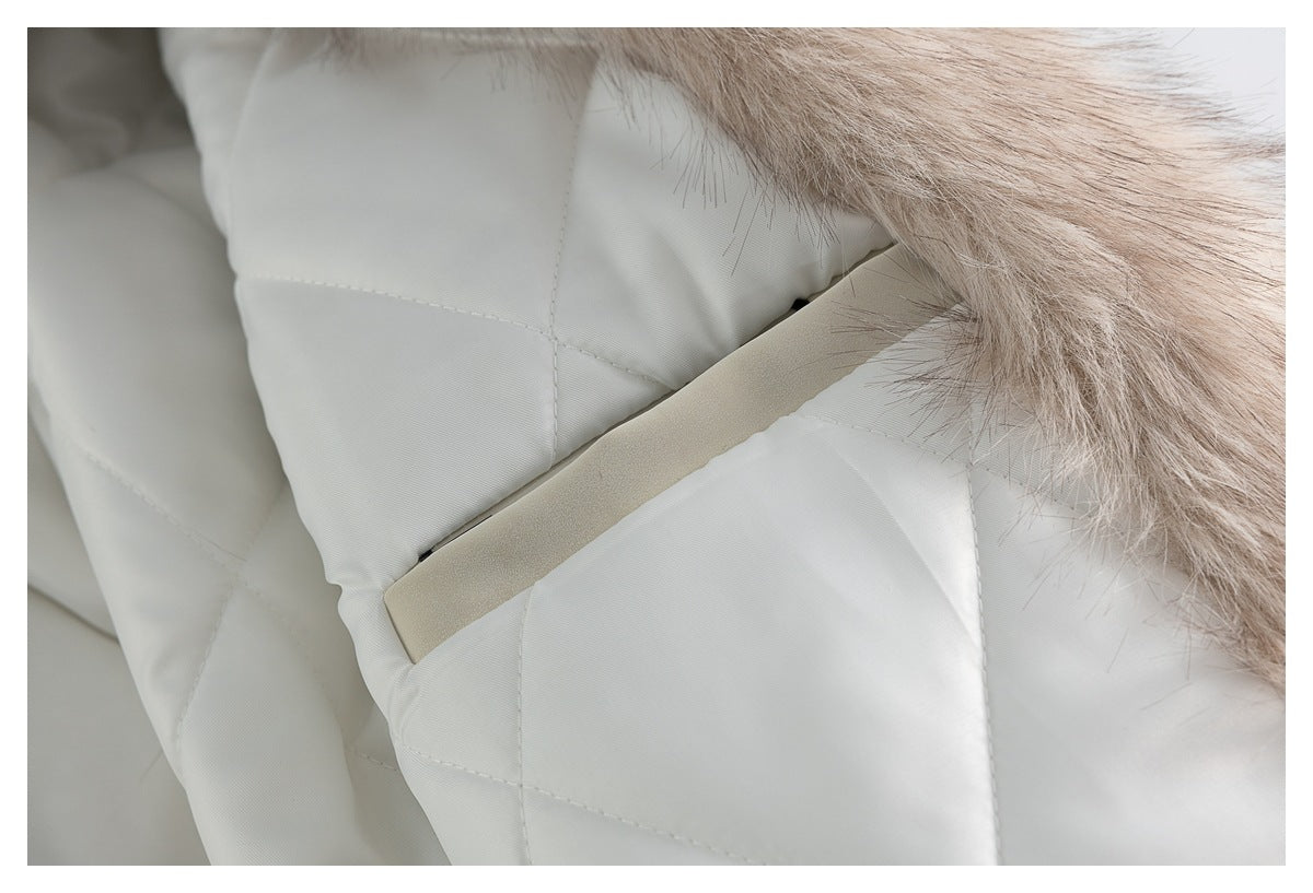 Close-up of an ivory quilted coat pocket with pale faux-fur trim along the edge.