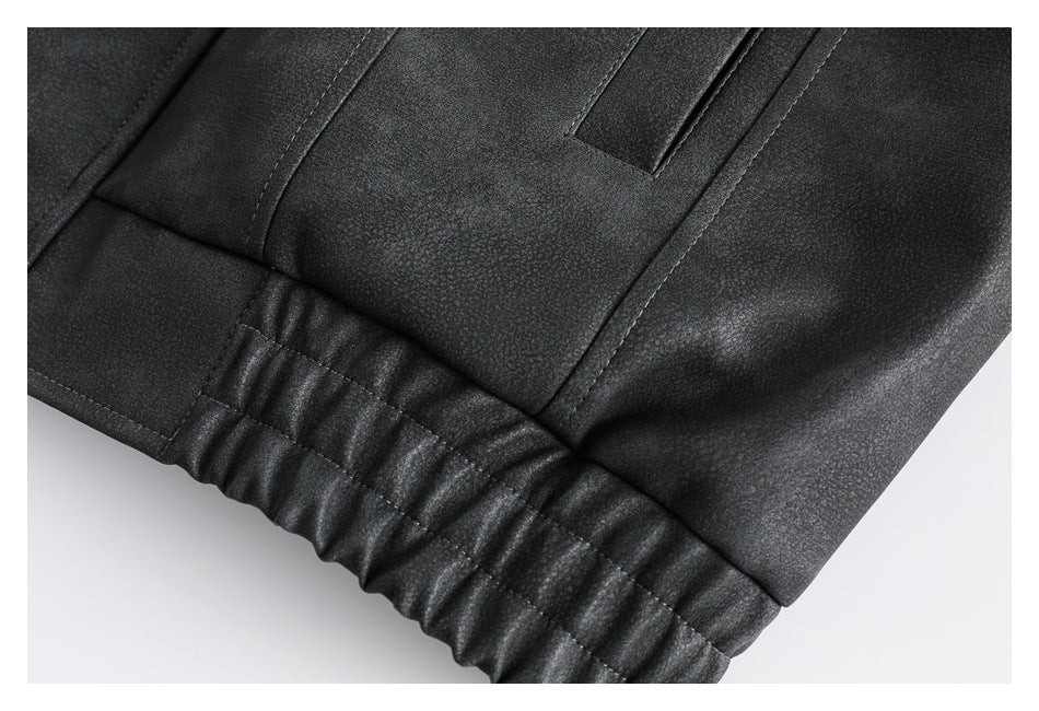 Close-up of a dark jacket showing a gathered elastic hem and nearby stitched panels.