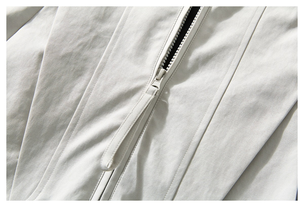 Close-up of the off-white jacket's front zipper, zipper guard, and stitched panels.