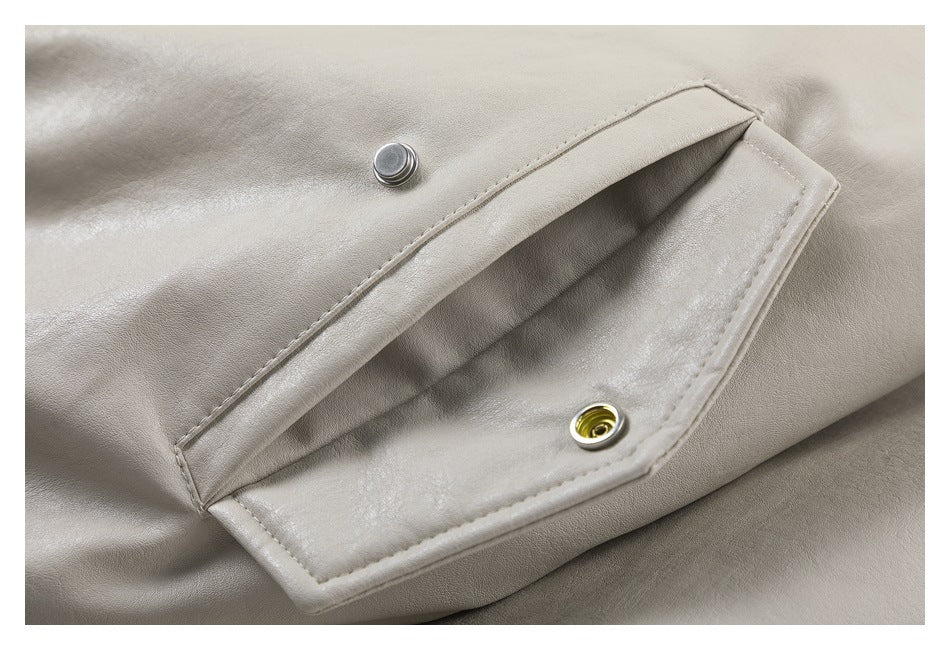 Close-up of a flap pocket with metal snap hardware on the light beige jacket.