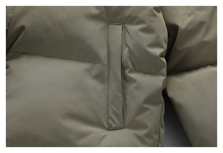 Close-up of a vertical welt pocket and horizontal quilting on the gray-green puffer jacket.
