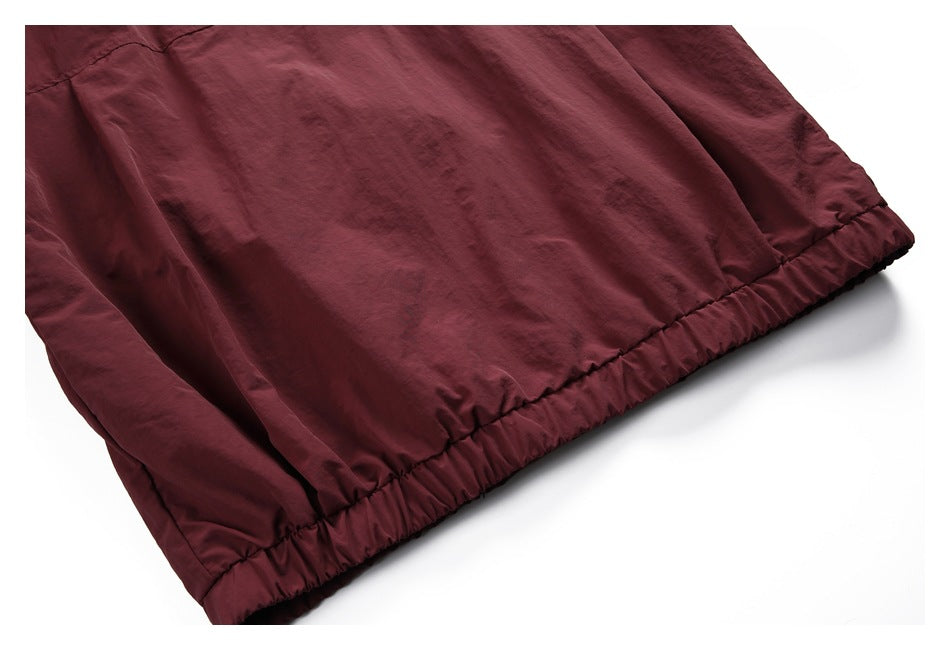 Close-up of a burgundy jacket with a gathered elastic hem.