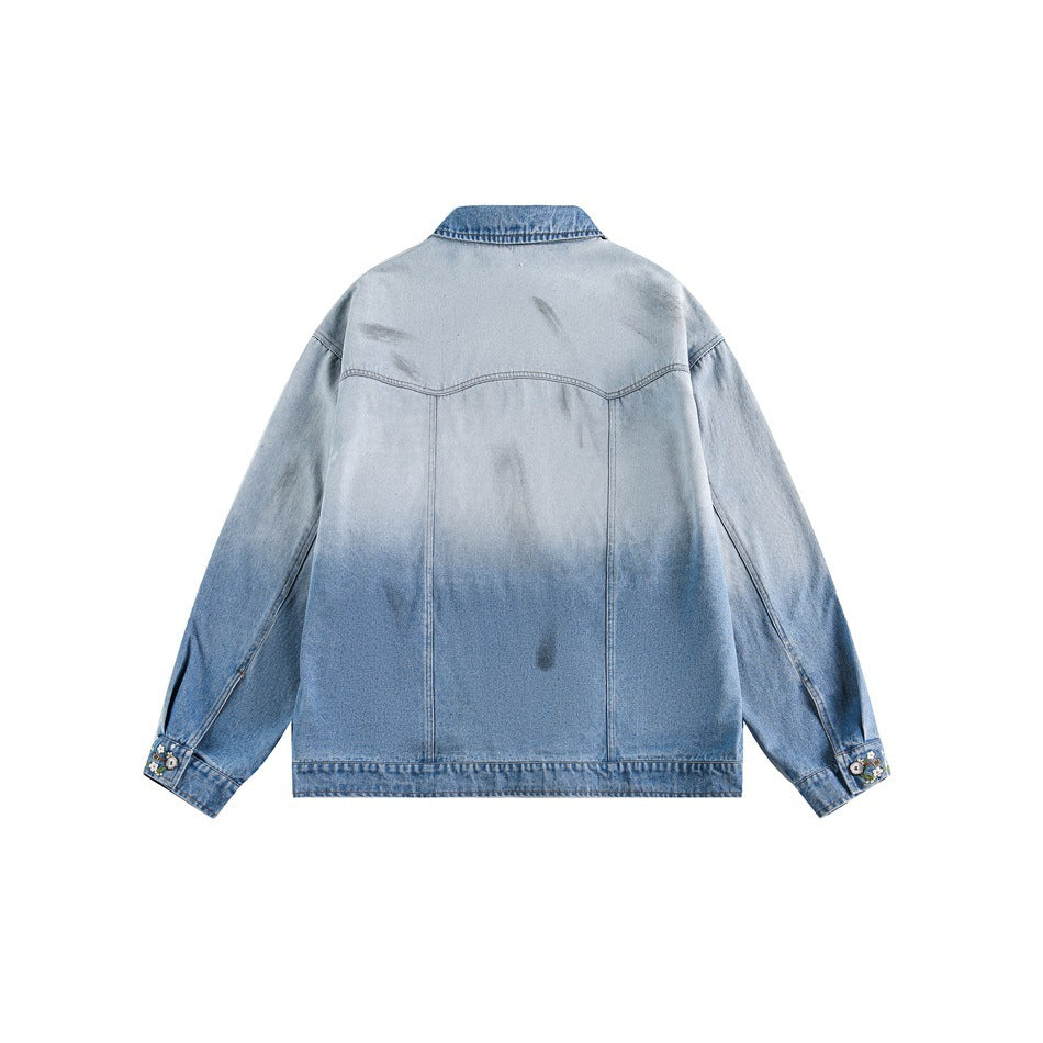 Back of a light blue jacket showing a yoke seam, panel seams, faded finish, and embroidered cuffs.
