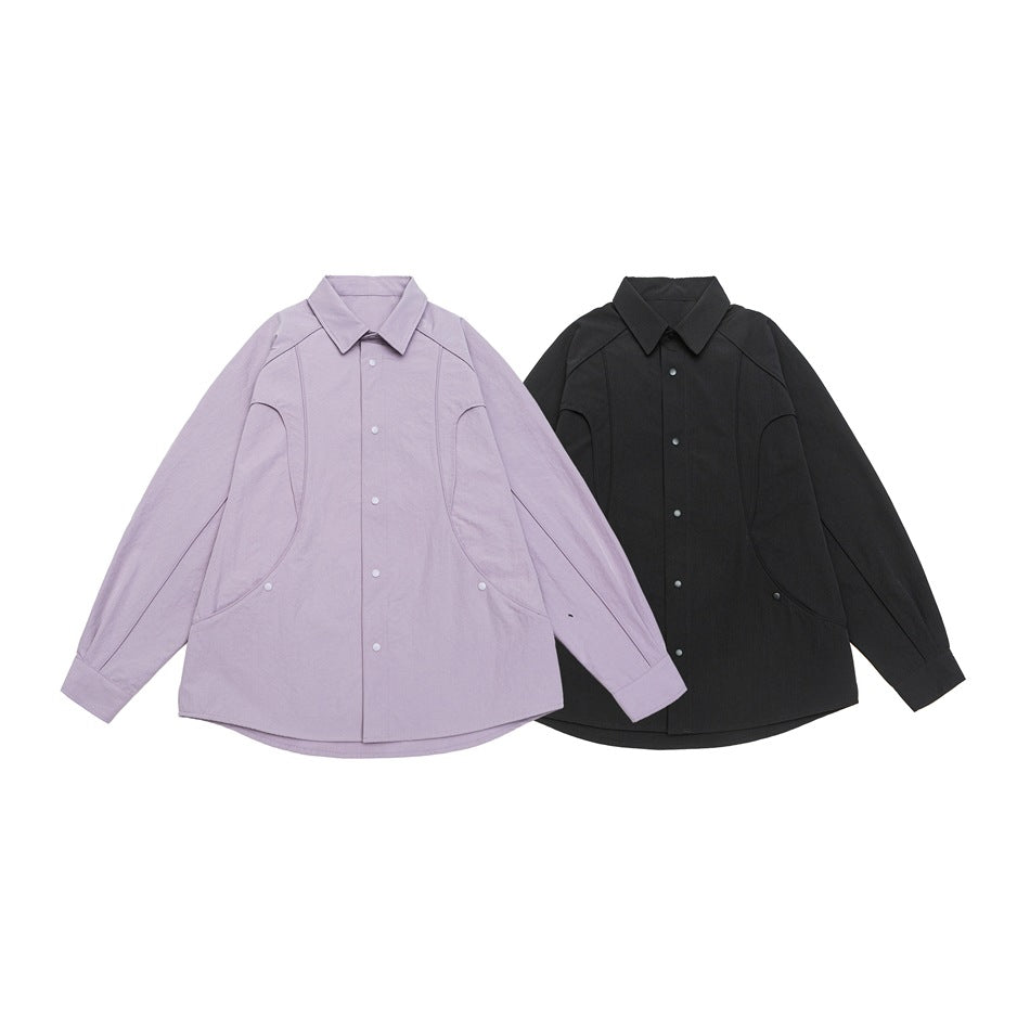 Two collared snap-front shirts laid flat side by side in pale lilac and black.