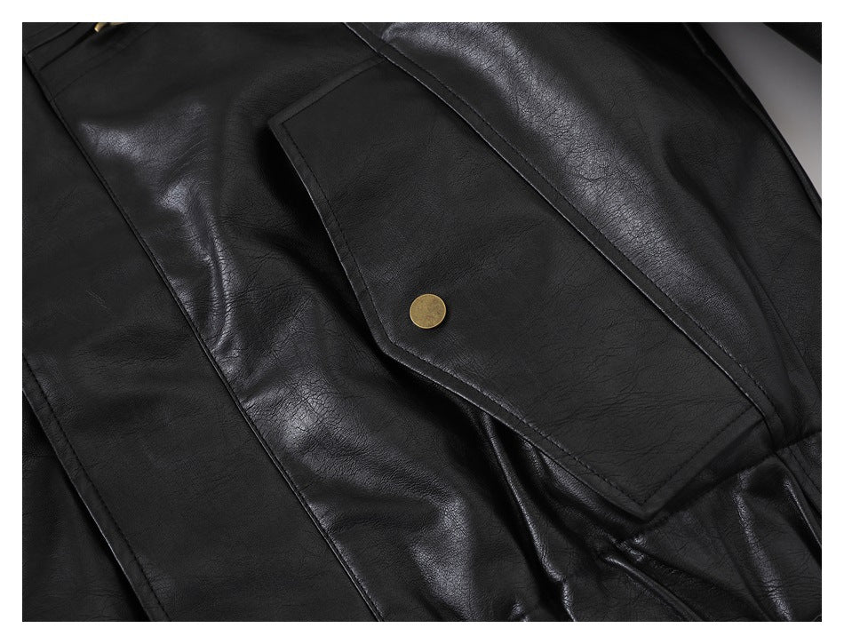 Close-up of a black jacket's large flap pocket with a round brass-colored snap.