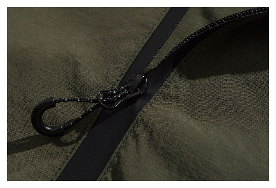 Close-up of an olive garment with a black zipper and corded zipper pull.