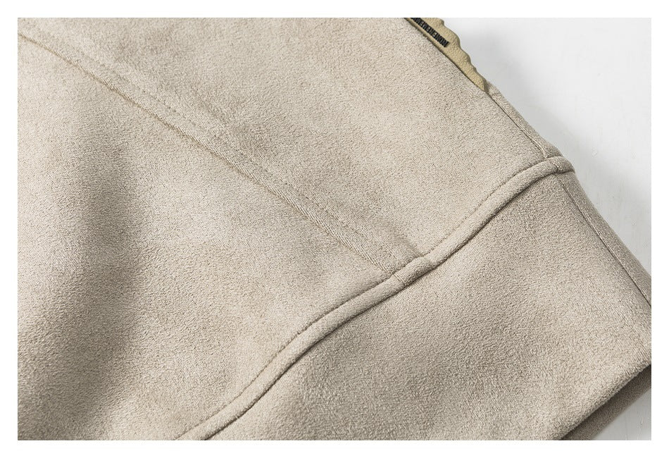 Close-up of a beige garment showing a curved stitched seam and folded edge.