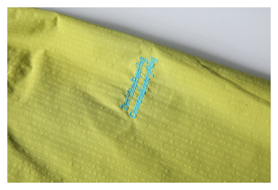 Lime-yellow shorts detail with small turquoise embroidered English lettering.