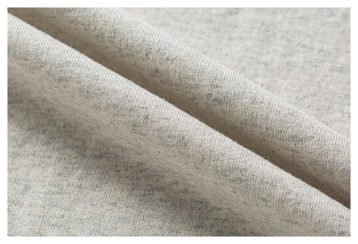 Close-up showing the drape and knit texture of light gray heathered fabric.