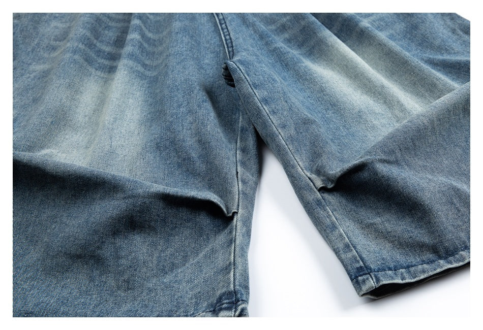Close-up of the blue denim garment's wide leg openings and stitched hems.
