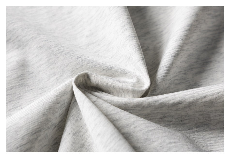 Close-up of light gray heathered fabric arranged in soft folds.