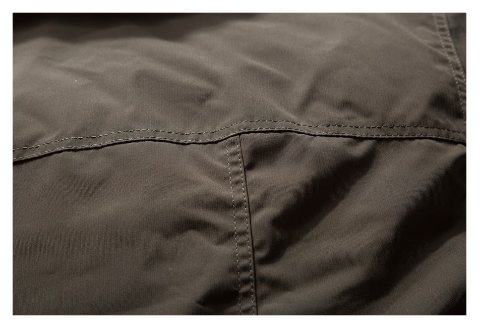 Close-up of dark brown garment fabric with curved double stitching and a vertical seam.